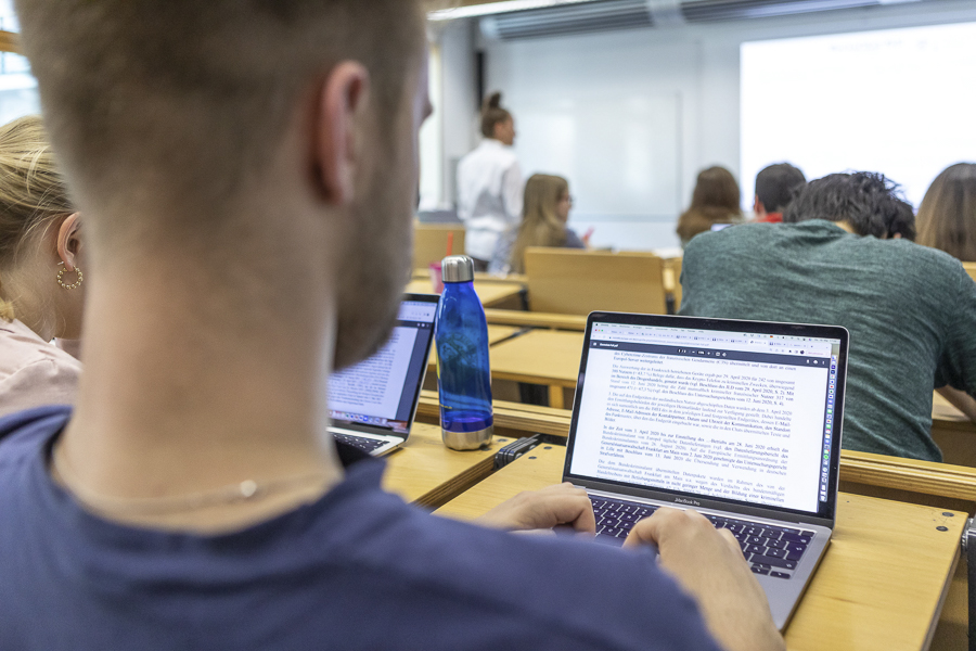 Student sitzt am Laptop im Vorlesungssaal